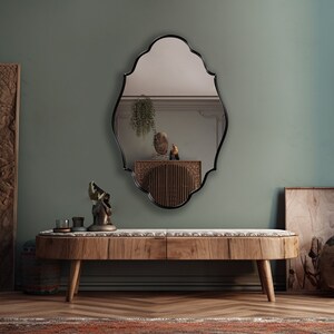 Renaissance Mirror with black frame hung on the wall of an entryway.