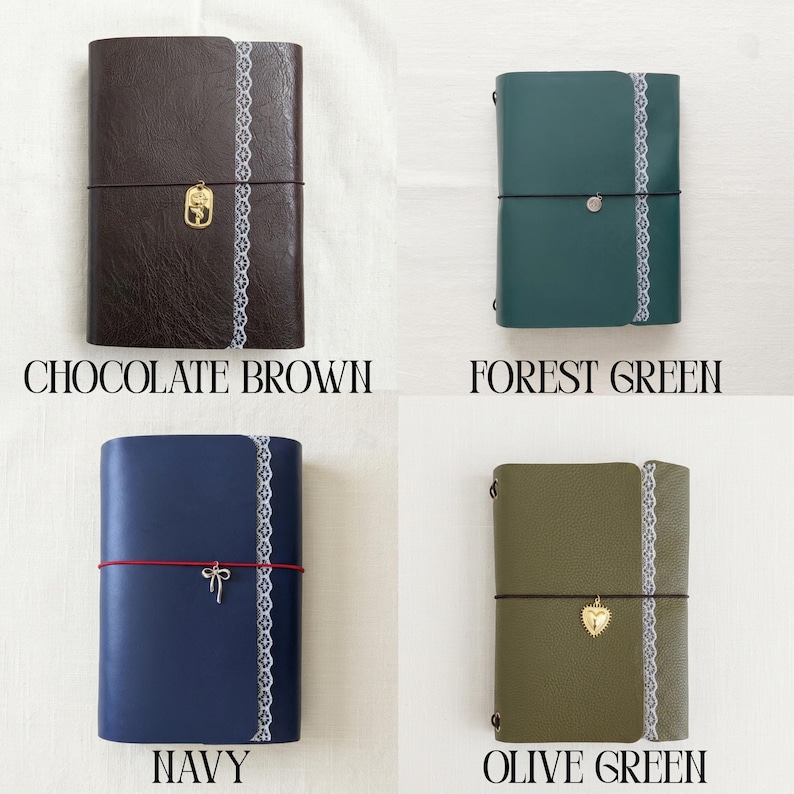 May include: Four rectangular journals in chocolate brown, forest green, navy, and olive green. Each journal features a vertical white lace trim, a horizontal elastic closure band, and a small metal charm including a rose, heart, or bow.