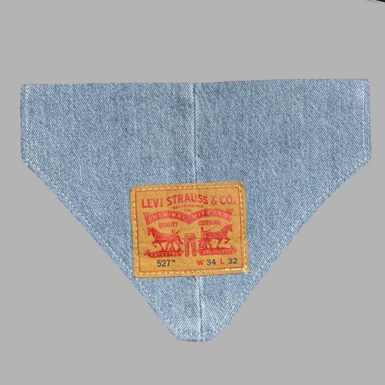 K&ouml;nnte beinhalten: Hellblaues Denim-Bandana mit einer gen&auml;hten Kante. Verf&uuml;gt &uuml;ber ein rechteckiges braunes Lederpatch mit dem Levi Strauss & Co. Logo in Rot. Das Patch enth&auml;lt Text und die Nummer "527" und die Ma&szlig;e "W 34 L 32".