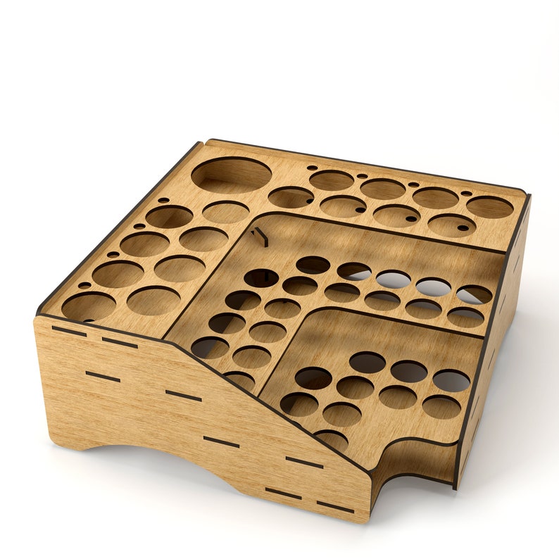 May include: Wooden organizer with multiple circular cutouts for storing small items. The organizer has a tiered design with a slanted front and a back panel with vertical slots.