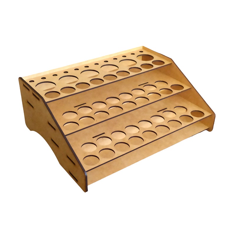 May include: A wooden paint rack with three tiers of circular holes for holding paint bottles. The rack is made of light brown wood and has a slightly curved base.