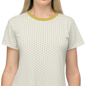 Könnte beinhalten: Ein weißes T-Shirt-Kleid mit einem kleinen, sich wiederholenden Muster aus goldenen Pluszeichen.