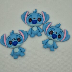Puede incluir: Tres figuras azules de un personaje con orejas grandes, interior de las orejas rosa y ojos en forma de coraz&oacute;n. Las figuras tienen una nariz azul y un cuerpo peque&ntilde;o y redondo. Est&aacute;n dispuestas sobre una superficie blanca.