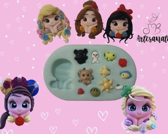 Puede incluir: Colección de figuras hechas a mano de arcilla polimérica, que incluyen personajes de princesas y pequeñas figuras de animales. Las figuras son de varios colores y estilos, con un molde verde claro en el centro. El fondo es rosa con formas de corazón blancas.