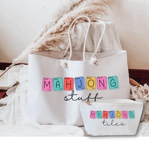 May include: White tote bag and matching pouch set. The tote bag has white rope handles and the words "MAHJONG stuff" in colorful block letters. The pouch has the words "MAHJONG tiles".