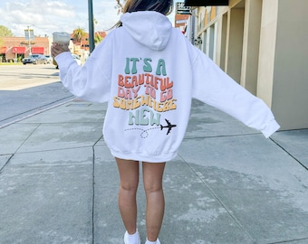 May include: White hoodie with a colorful graphic that says "It's a beautiful day to go somewhere new" and a small airplane graphic.