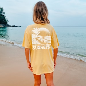 May include: A yellow t-shirt with a white graphic of a beach scene and the text "Chasing Sunsets".