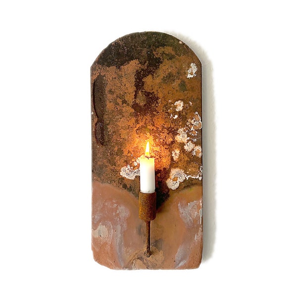 Antique roof tile with rusty metal candle holder