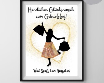 May include: Black framed print with a silhouette of a person holding shopping bags, wearing a patterned skirt, and high heels. The print includes German text: "Herzlichen Glückwunsch zum Geburtstag!" and "Viel Spaß beim Ausgeben!"