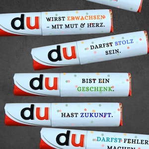 May include: A collection of six candy bar wrappers with the word "du" in a bold, black font. Each wrapper has a different message in German, such as "You are a gift" and "You have a future."
