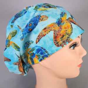 May include: A blue scrub hat with a colorful sea turtle pattern. The hat is made of a soft, comfortable fabric and is perfect for nurses, doctors, and other healthcare professionals.