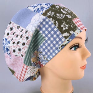 Puede incluir: Un gorro quirúrgico de patchwork con una variedad de patrones de tela, incluyendo florales, cuadros y colores lisos en azul, rosa, verde y blanco. El gorro se muestra en una cabeza de maniquí.