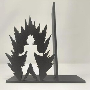 May include: A black metal bookend set featuring a silhouette of a character with spiky hair and energy bursts. The bookends are designed to stand upright, providing support for books. The design is a stylized representation of a popular anime character.