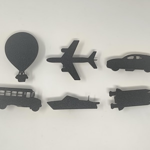 Puede incluir: Siluetas de varios modos de transporte, incluyendo un globo aerostático, un avión, un automóvil, un autobús escolar, un barco y un cohete. Las siluetas son negras sobre un fondo blanco.