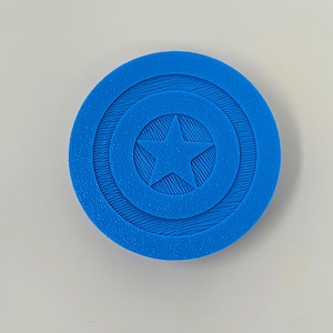 May include: A blue plastic 3D printed replica of Captain America's shield. The shield has a white star in the centre and concentric circles around the star.