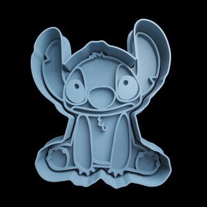 May include: A blue plastic cookie cutter shaped like Stitch from the Disney movie Lilo & Stitch.