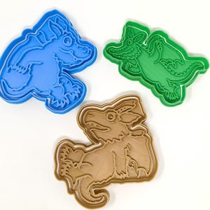 Peut inclure: Trois emportes-pièces en forme de dragons. Les emportes-pièces sont en plastique et sont bleus, verts et bruns.