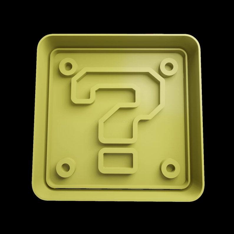 Puede incluir: Un bloque amarillo con forma de signo de interrogaci&oacute;n con cuatro peque&ntilde;os c&iacute;rculos alrededor de los bordes. El bloque es una representaci&oacute;n 3D de un objeto cl&aacute;sico de videojuego.