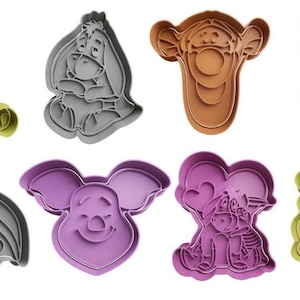 Peut inclure: Ensemble de huit emporte-pièces en forme de personnages de Winnie l'ourson. Les emporte-pièces sont en plastique et de différentes couleurs, notamment vert, gris, violet et marron. Les emporte-pièces représentent Winnie l'ourson, Porcinet, Bourriquet et Tigrou.