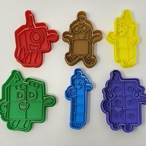 Könnte beinhalten: Satz mit sechs bunten Plastik-Ausstechern in Form von Figuren aus der Kindersendung 'Numberblocks'. Die Figuren sind 1, 2, 3, 4, 5 und 6.