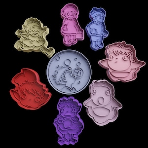 Pode incluir: Conjunto de nove cortadores de biscoitos com personagens do filme de animação 'Meu Vizinho Totoro'. Os cortadores são feitos de plástico azul claro, rosa, vermelho e cinza. Os personagens incluem Totoro, uma menina com um gato, uma menina com uma cesta e uma menina soprando bolhas.