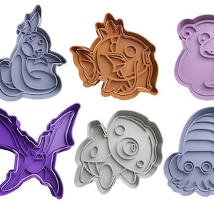 Könnte beinhalten: Satz mit sechs Ausstechern mit verschiedenen Pokémon-Charakteren. Die Ausstecher sind aus Kunststoff und in den Farben Lila, Braun und Grau.