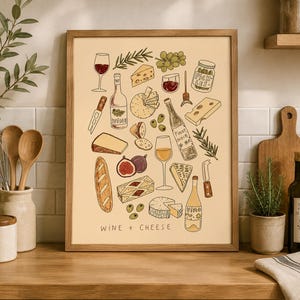 May include: A framed wall art print featuring a cream-coloured background with hand-drawn illustrations of wine bottles, various cheeses, grapes, figs, bread, olives, and pickles. The text WINE + CHEESE is printed in black at the bottom of the print.