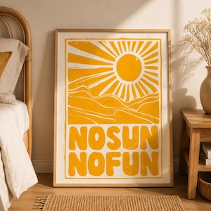 May include: A rectangular framed wall art print featuring a bright yellow graphic of a sun shining over rolling hills. The text "NOSUN NOFUN" is printed in large, bold yellow capital letters at the bottom of the white background within the frame.