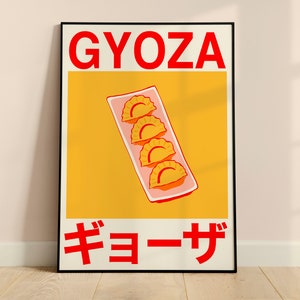 May include: A framed poster featuring a stylized illustration of gyoza dumplings. The word "GYOZA" is in red block letters at the top, with Japanese characters below. The dumplings are arranged on a rectangular plate against a yellow background.