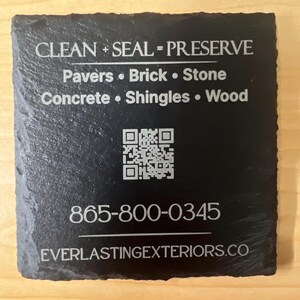 May include: A black square slate coaster with white text. The text reads "CLEAN + SEAL = PRESERVE" followed by a list of materials. A QR code and a phone number are also visible, along with a website address.
