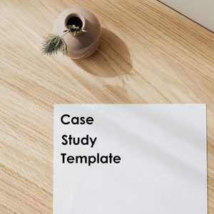 Könnte beinhalten: Ein weißes Blatt Papier mit dem Text "Case Study Template" in Schwarz auf einer Holzoberfläche. Eine kleine Vase mit einer getrockneten Pflanze befindet sich in der oberen linken Ecke des Bildes.