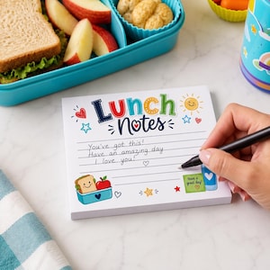 Puede incluir: Un bloc de notas cuadrado con el texto Lunch Notes en la parte superior, con ilustraciones coloridas de un sol, estrellas, corazones y un s&aacute;ndwich en un recipiente. El bloc tiene papel rayado con el texto escrito a mano You've got this! Have an amazing day. I love you!