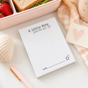 May include: A white rectangular notepad featuring the black printed text A Little Note just for you with a small red heart icon. The bottom section includes a horizontal line, a small black star icon, and the printed word Love followed by a blank line.