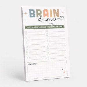 May include: A white notepad with the text BRAIN dump and a heart icon at the top. Below is a date line and a green bar with the text GET IT OUT. CLEAR YOUR MIND. FOCUS ON WHAT MATTERS. It features two columns of checkboxes with lines and a grid section.