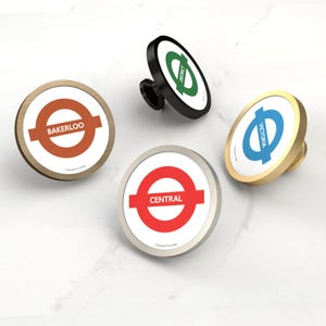 Può includere: Quattro pomelli decorativi per mobili con design della metropolitana di Londra. I pomelli presentano una superficie circolare con i nomi "Bakerloo", "Central", "District" e "Victoria". Finiture: legno, nero, argento e oro.