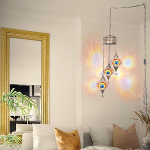 Op de afbeelding: Een meertraps hanglamp met drie kleurrijke mozaïekglazen bollen. De bollen hangen aan een ketting en geven een warm, uitnodigend licht.