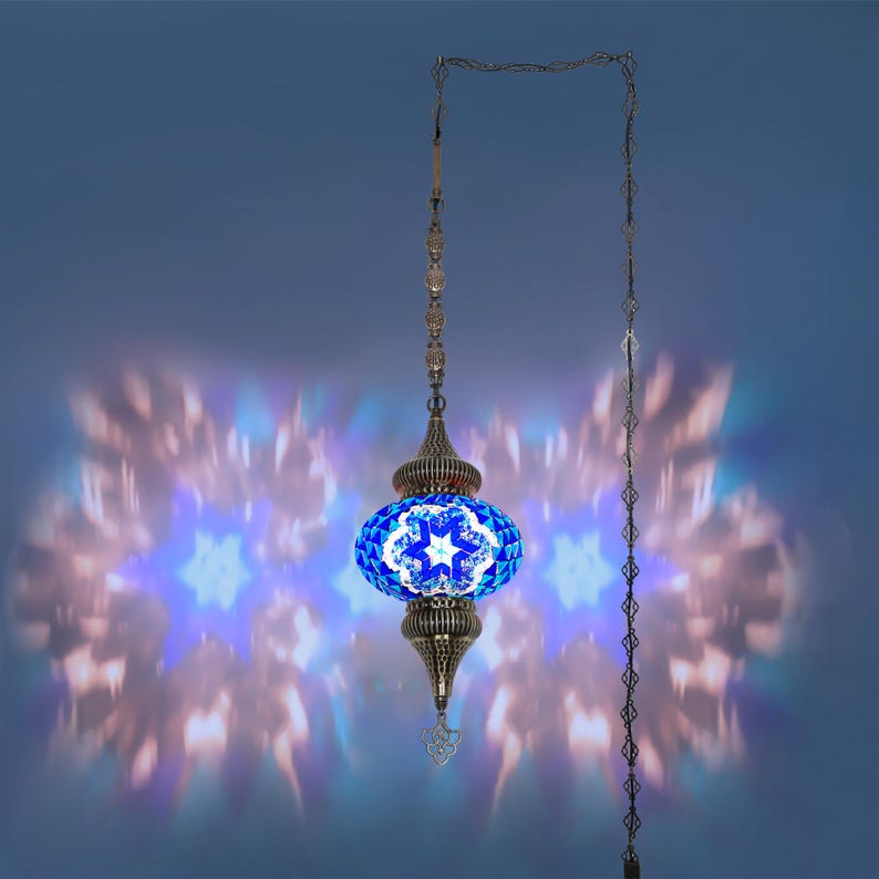 K&ouml;nnte beinhalten: Eine verzierte H&auml;ngelampe mit einem blau-wei&szlig;en Mosaikglasschirm. Die Lampe hat einen Metallrahmen und eine Kette, die ein sternf&ouml;rmiges Lichtmuster projizieren. Das Design der Lampe erinnert an t&uuml;rkische oder marokkanische Stile.