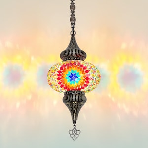 K&ouml;nnte beinhalten: Eine farbenfrohe Pendelleuchte im Mosaikstil mit Sternmuster. Die Lampe verf&uuml;gt &uuml;ber eine lebendige Anordnung aus roten, orangen, gelben, gr&uuml;nen und blauen Glasteilen. Der Metallrahmen hat eine antike Bronze-Oberfl&auml;che und die Lampe h&auml;ngt an einer Kette.