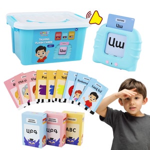 May include: A light blue talking flash card set for children. The set includes a storage box, a card reader, and multiple flash cards with illustrations and text. The box and reader have the text "TALKING FLASH CARDS" and "LEVEL 1".
