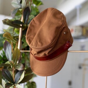 Discover our transformable hat, crafted from organic cotton and accompanied by an up-cycled leather pin.