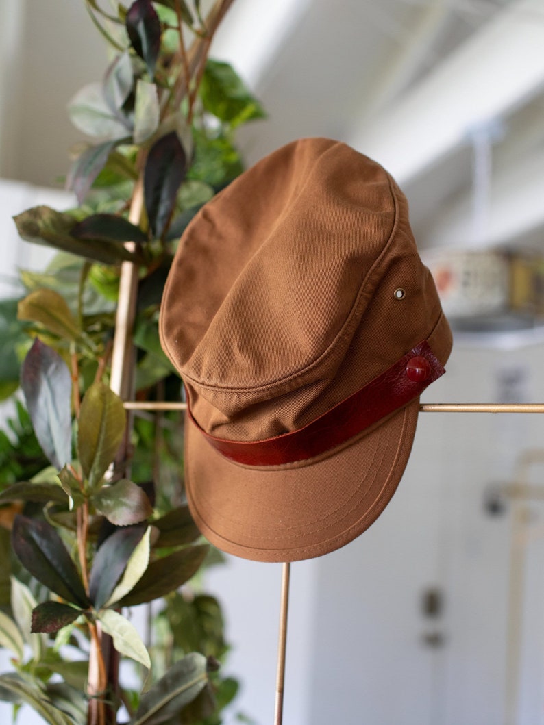 Discover our transformable hat, crafted from organic cotton and accompanied by an up-cycled leather pin.