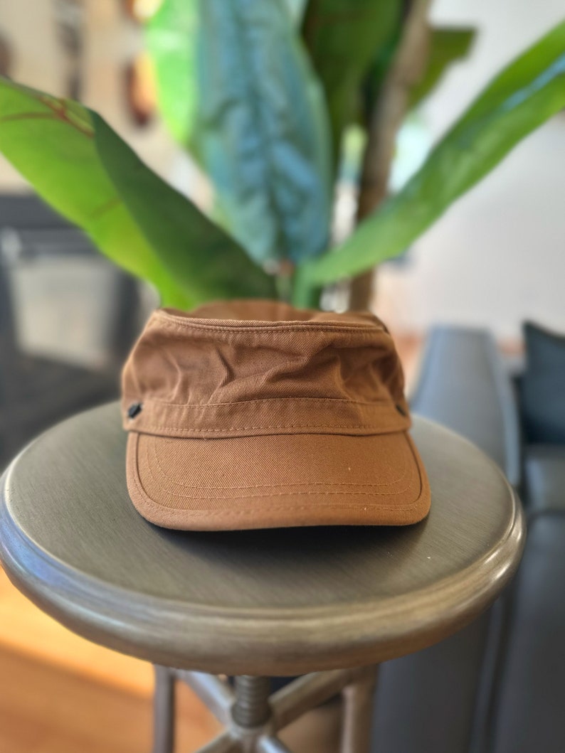 Discover our transformable hat, crafted from organic cotton and accompanied by an up-cycled leather pin.