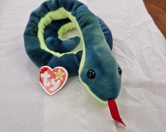 Pode incluir: Uma cobra de pelúcia verde e azul com uma língua vermelha. A cobra está enrolada e tem uma etiqueta Ty Beanie Baby.