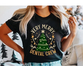 May include: A black t-shirt with a gold and green design featuring a Christmas tree and the text "Very Merry Dental Crew".