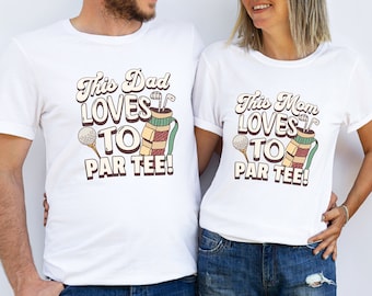 May include: Two white t-shirts with a golf-themed design. The text on the shirts reads "This Dad Loves to Par Tee!" and "This Mom Loves to Par Tee!"