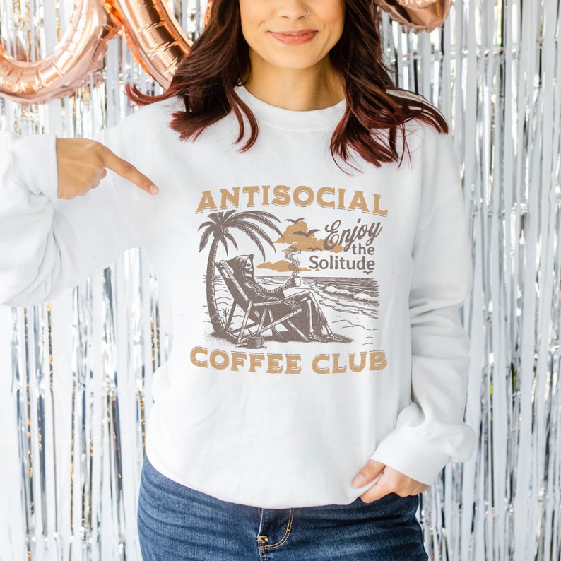 May include: White sweatshirt with a brown graphic of a skeleton sitting on a beach chair with a coffee cup. The graphic says "Antisocial Enjoy the Solitude Coffee Club".