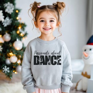 May include: A grey sweatshirt with the text "Passionate about DANCE" in black with a silhouette of dancers in the word "DANCE".