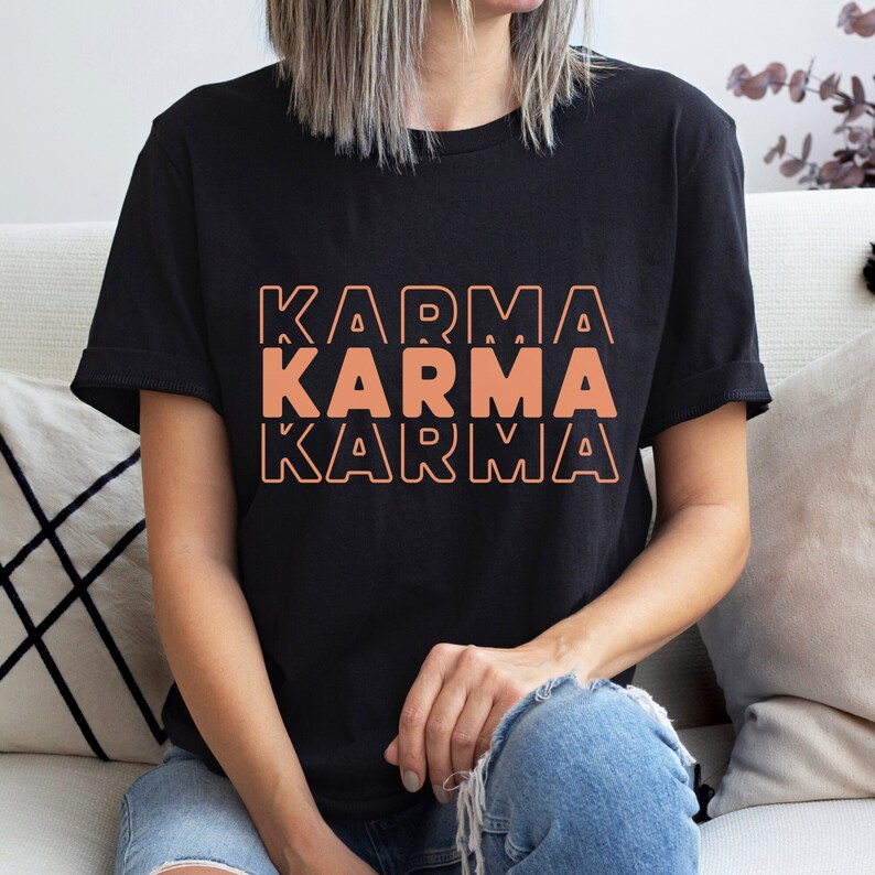 Może przedstawiać: Czarny T-shirt z napisem "KARMA" powt&oacute;rzonym trzy razy w ułożonej, brzoskwiniowej czcionce.