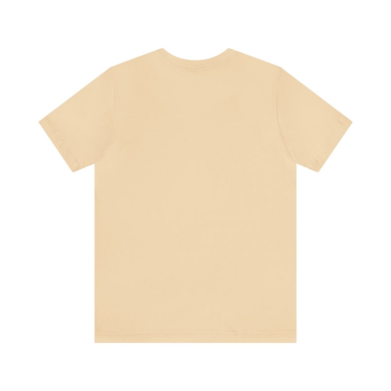 May include: A plain, light beige t-shirt with short sleeves.