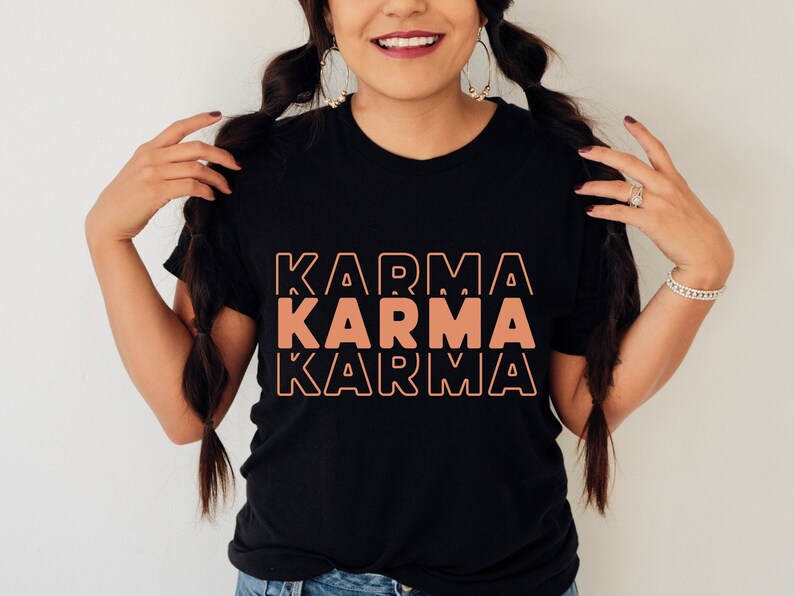 Może przedstawiać: Czarny T-shirt z tekstem "KARMA" powt&oacute;rzonym trzy razy w kolorze brzoskwiniowym. Tekst jest w pogrubionej, retro czcionce.